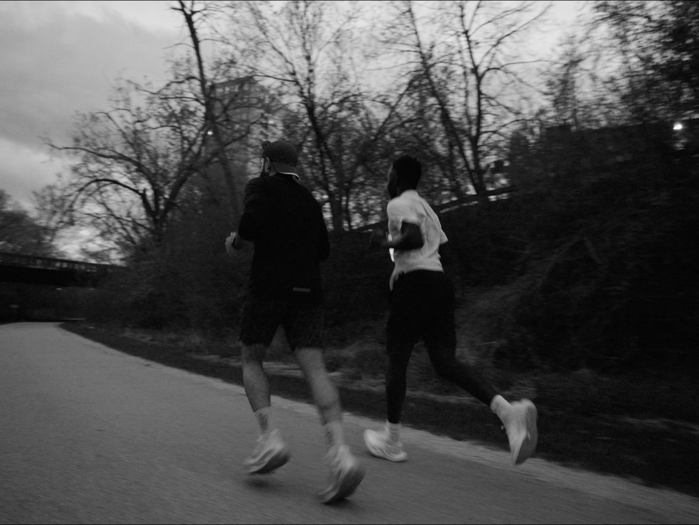 Two runners on the Oak Leaf Trail at dusk, in black and white
