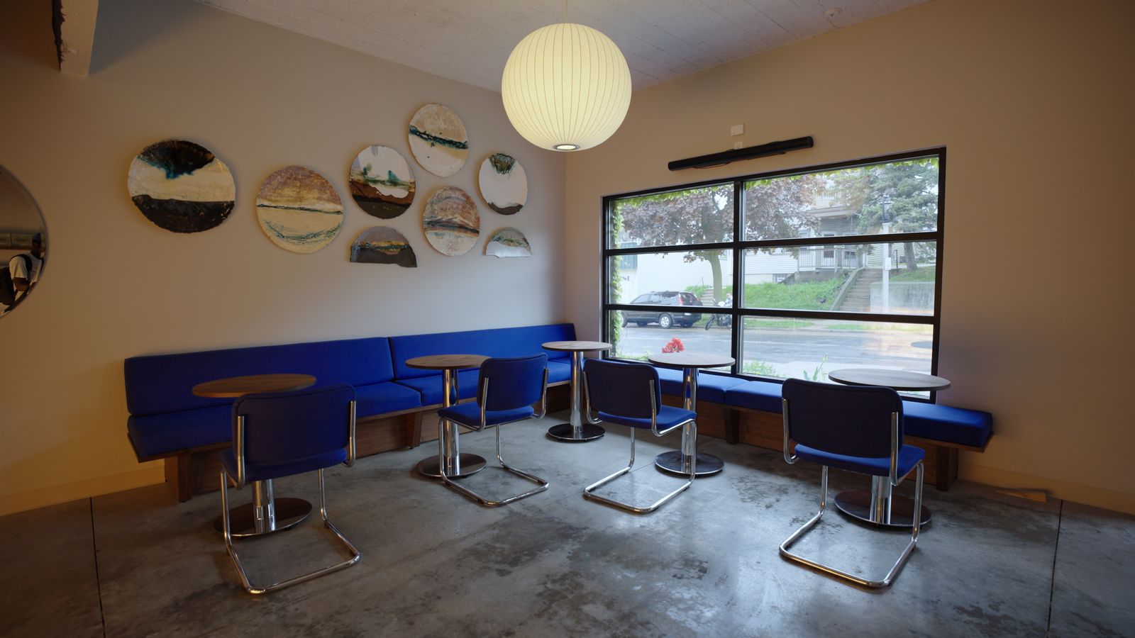 Blue Hour Coffee seating area with cobalt banquette and ceramic wall art